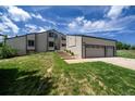 Charming exterior of two-story home featuring a spacious three-car garage and landscaped front yard at 9163 N Palomino Dr, Castle Rock, CO 80108