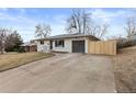 Well-kept one-story home with long driveway, modern garage door, and privacy fence at 2765 S Winona Ct, Denver, CO 80236