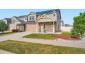 Two story home with large green lawn and stone and siding exterior, complemented by a two car garage at 4404 Walden St, Denver, CO 80249