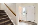 Bright foyer featuring hardwood floors, staircase, and a white front door with side window at 4404 Walden St, Denver, CO 80249