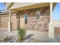 Close-up of the front entrance showcasing stone siding, a covered porch, and well-maintained landscaping at 4404 Walden St, Denver, CO 80249