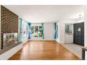 Bright living room with hardwood floors, a brick fireplace, and large windows at 6212 S Pennsylvania St, Centennial, CO 80121