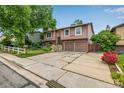 Attractive home with two car garage, mature trees, and a white picket fence at 9832 High St, Thornton, CO 80229