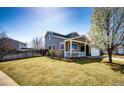Well-kept home with a fenced yard, lush grass, and blossoming tree at 2070 E 125Th Pl, Thornton, CO 80241