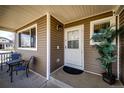 Inviting front porch featuring a seating area, potted plant, and a white front door at 2070 E 125Th Pl, Thornton, CO 80241
