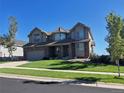 Two-story house with gray siding, a large yard, and a three-car garage at 12198 Tack Dr, Parker, CO 80134