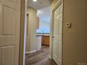 Hallway view leading to kitchen with hardwood floors and neutral paint scheme at 15475 E Andrews Dr # 402, Denver, CO 80239