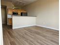 Open floor plan featuring living room with hardwood floors adjacent to the kitchen at 15475 E Andrews Dr # 402, Denver, CO 80239