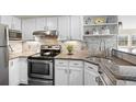 Well-lit kitchen featuring stainless appliances and stone backsplash at 4760 S Wadsworth Blvd # K205, Littleton, CO 80123