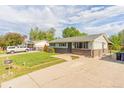 Ranch style home with a green lawn, fenced yard, and spacious driveway for parking at 2630 W Asbury Ave, Denver, CO 80219