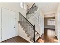 Elegant foyer with dark hardwood flooring, a staircase with wrought iron railings, and a view into the living spaces at 17040 Galapago Ct, Broomfield, CO 80023