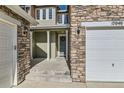 Inviting front porch featuring stone accents, white columns, and a charming front door at 17040 Galapago Ct, Broomfield, CO 80023