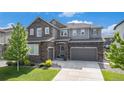 Charming two-story home with a stone and siding exterior, landscaped front yard, and attached two-car garage at 1195 Fox Hills Ct, Erie, CO 80516