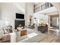 Inviting living room with a fireplace, high ceilings, large windows, and modern decor at 1195 Fox Hills Ct, Erie, CO 80516