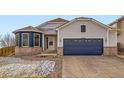 Attractive home featuring blue siding, brick accents, a large garage, and a well-kept front yard at 4296 Clover Ln, Brighton, CO 80601