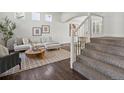 Bright living room featuring hardwood floors, a modern staircase, and tasteful decor at 12695 Wolff St, Broomfield, CO 80020