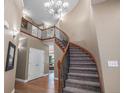 Grand foyer with a curved staircase, wood floors, and an elegant chandelier at 15562 E 109Th Ave, Commerce City, CO 80022