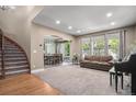 Spacious living room flowing into the dining room, featuring a large window and staircase at 15562 E 109Th Ave, Commerce City, CO 80022