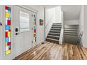 Welcoming foyer with hardwood floors, a stained glass front door, and a staircase at 2853 Yosemite St, Denver, CO 80238