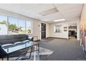 Open office area with a couch, a large window, grey carpet, and a view from the entrance door at 1050 S Quitman St, Denver, CO 80219