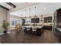 Modern kitchen featuring dark wood cabinets, a large granite island, and stainless steel appliances at 228 Rogers Ct, Castle Rock, CO 80104
