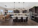 Gourmet kitchen featuring an expansive island with seating, stainless steel appliances, and dark wood cabinetry at 228 Rogers Ct, Castle Rock, CO 80104