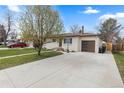 Charming single story home with a freshly painted exterior, spacious driveway and mature landscaping at 3055 S Winona Ct, Denver, CO 80236