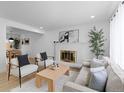 Bright living room with white brick fireplace, light wood floors and contemporary furnishings at 3055 S Winona Ct, Denver, CO 80236