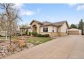 Inviting home with stone accents, mature trees, and a long driveway leading to a detached garage at 6071 S Detroit St, Centennial, CO 80121
