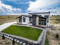 Striking modern home featuring well-manicured lawn, stone accents, and contemporary design at 8765 Canyon Wind St, Parker, CO 80138