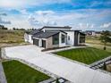 Beautiful modern home with a long driveway, pristine lawn, and stylish architectural details at 8765 Canyon Wind St, Parker, CO 80138