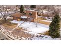 Aerial view of a brick home with a large yard, mature trees, and a detached garage at 9962 W 77Th Ave, Arvada, CO 80005