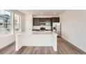 Modern kitchen features a large island, stainless steel appliances, and dark cabinetry at 2150 S Haleyville Way, Aurora, CO 80018