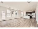 Bright, open-concept area with large windows, hardwood floors, and a view into the kitchen at 2150 S Haleyville Way, Aurora, CO 80018