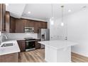 Modern kitchen with stainless steel appliances, white countertop island, and dark wood cabinetry at 1175 Highview Dr, Erie, CO 80516