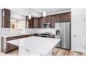 Modern kitchen with stainless steel appliances, white countertops and dark wood cabinets at 1175 Highview Dr, Erie, CO 80516