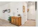 Entry hallway featuring light wood floors and an antique wood cabinet for storage and style at 4635 S Odessa St, Centennial, CO 80015