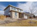 Side view of home with stone accents, a two-car garage, and solar panels at 5421 S Granby Way, Aurora, CO 80015