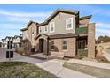 Two-story townhome with brick and siding exterior, a bench, and a small yard at 5199 S Fairplay St, Aurora, CO 80015