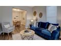 Comfortable living room with modern decor, a plush blue sofa, and a view into the dining area at 124 Elati St, Denver, CO 80223