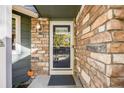 Front entrance with stonework, glass door, and a small porch at 13942 Jackson St, Thornton, CO 80602