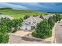 Stunning home with a lush green lawn, mature trees, and a charming covered front porch at 7866 Witney Pl, Lone Tree, CO 80124