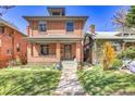 Charming brick two story house with a well-manicured lawn and inviting front porch at 161 S Pearl St, Denver, CO 80209