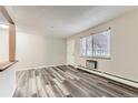 Inviting living room features sleek, gray wood-look flooring and ample natural light at 5875 E Iliff Ave # 115, Denver, CO 80222