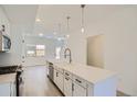 Modern kitchen with white cabinets, island, and stainless steel appliances at 15275 W 68Th Pl, Arvada, CO 80007