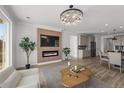 Open-concept living space with modern fireplace, chandelier lighting and view of the open kitchen at 180 N Edge Cliff St, Castle Rock, CO 80104