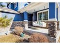 Inviting front porch with a swing, stone accents and comfortable seating creates a relaxing outdoor space, with plants and natural lighting at 1870 Alpine Dr, Erie, CO 80516