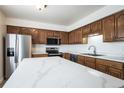 Bright kitchen features stainless appliances, white countertops, and light brown cabinets at 8627 Santa Fe Dr, Thornton, CO 80260