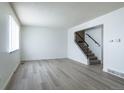 Bright living room with modern gray flooring and staircase access to upper level at 8627 Santa Fe Dr, Thornton, CO 80260