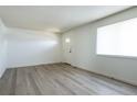 Open living room featuring gray flooring, ample natural light, and a welcoming front door at 8627 Santa Fe Dr, Thornton, CO 80260